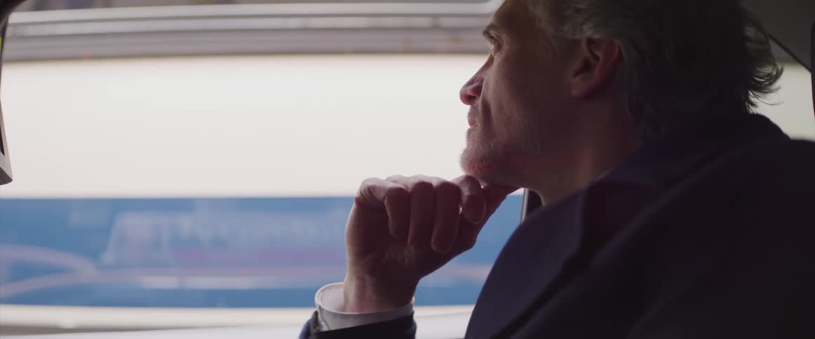 Businessman looks out the window of a moving car