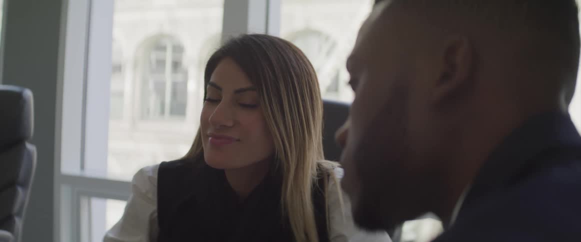 Two people talk in the conference room together