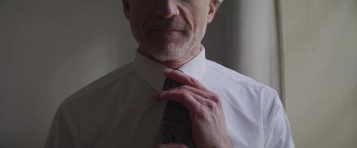 A man is adjusting his tie