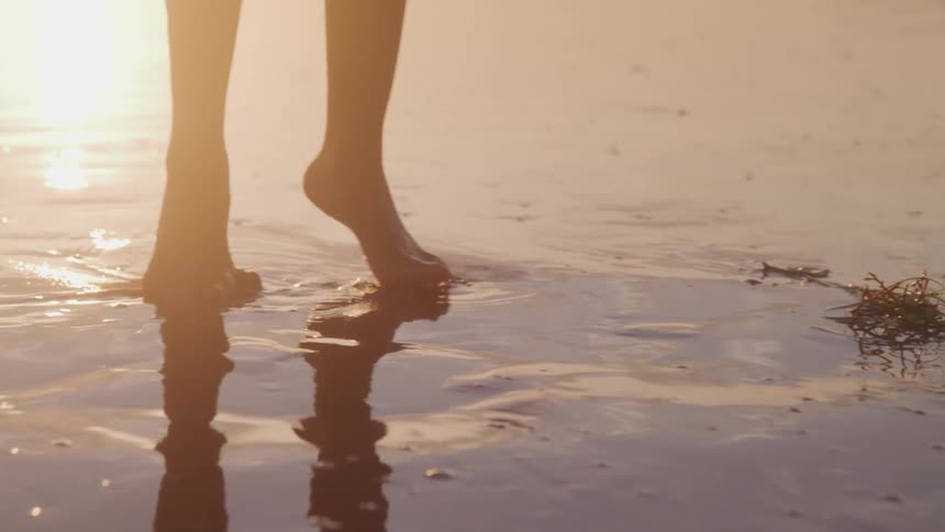 A person stepping from side to side in the wet sand of a beach