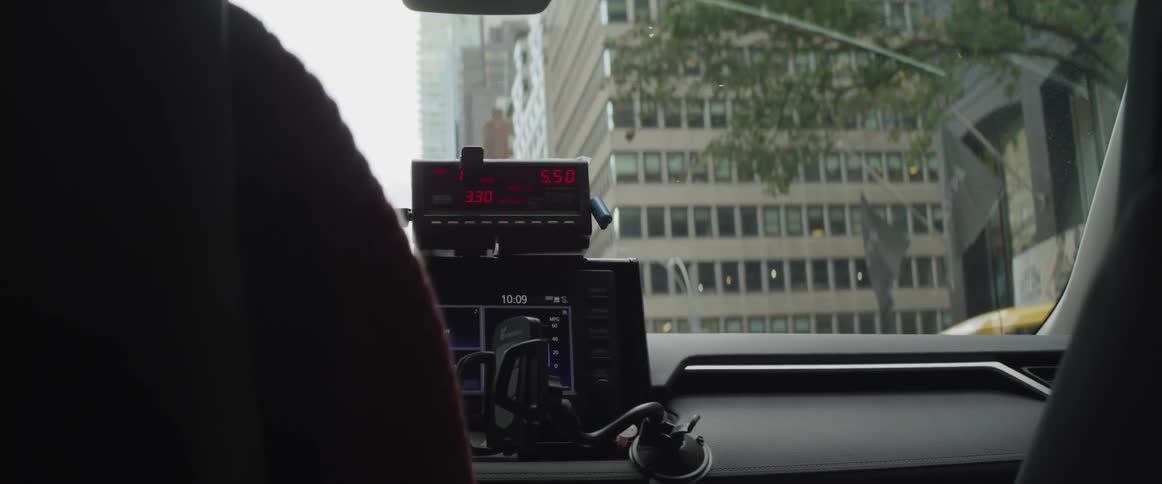 Cab meter in the dashboard of a taxi driving through city