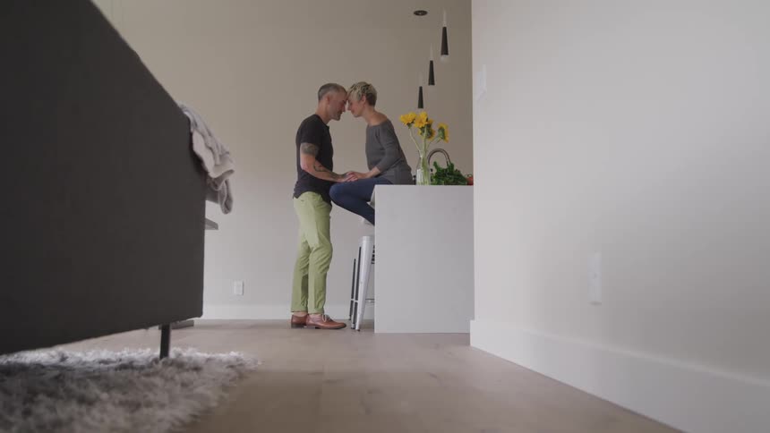 A husband and wife lean into each other and touch foreheads romantically
