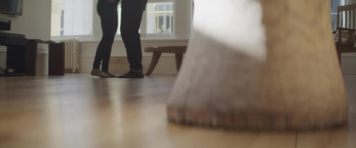 Man and woman dance together in the living room at home