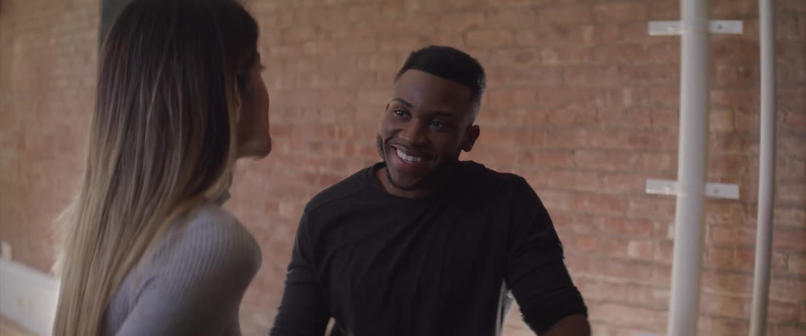 A man sits beside a woman and smiles at her