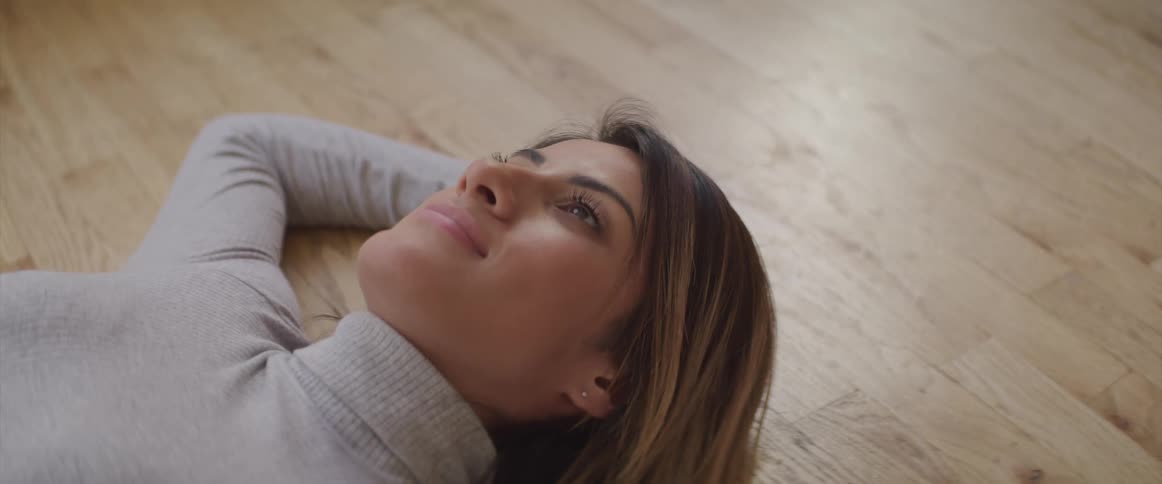 The woman relaxes on the floor