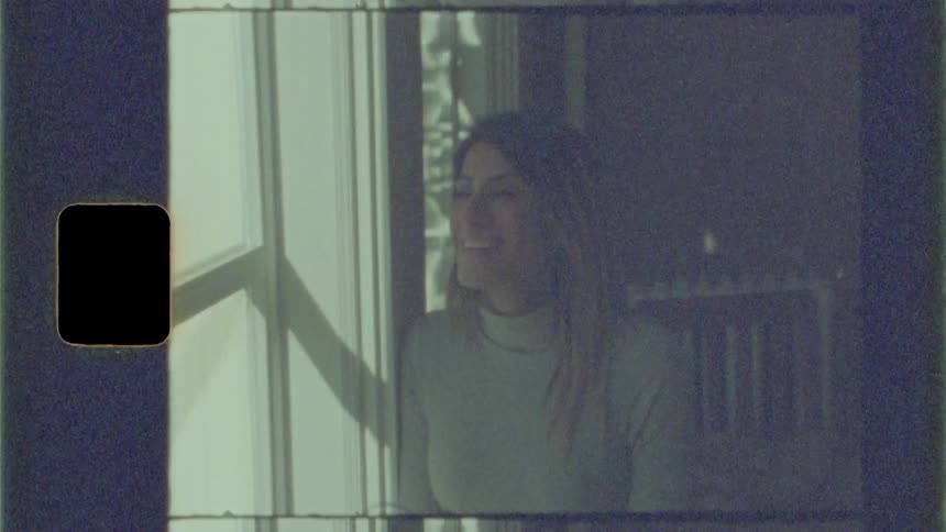 A woman leans against a wall and laughs