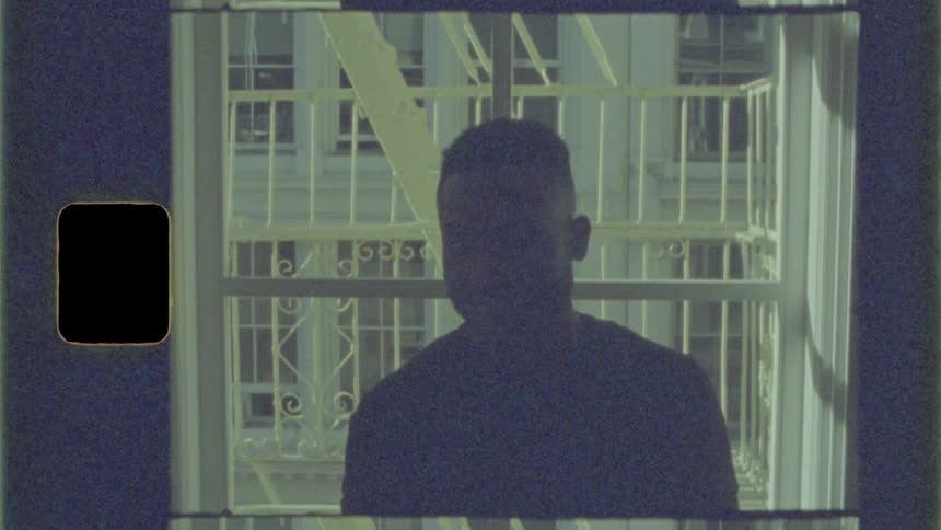 The man sits in front of the window