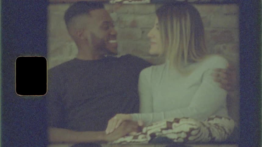 A young couple share a brief kiss