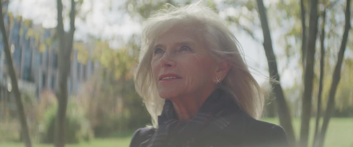 A woman is smiling in the park
