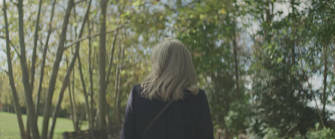 Woman walks along the pedestrian pathway in the public park
