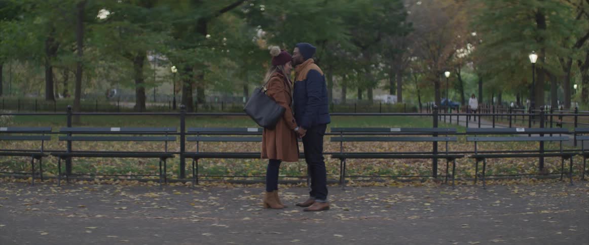 Romantic couple holding hands leaning towards each other at a public park