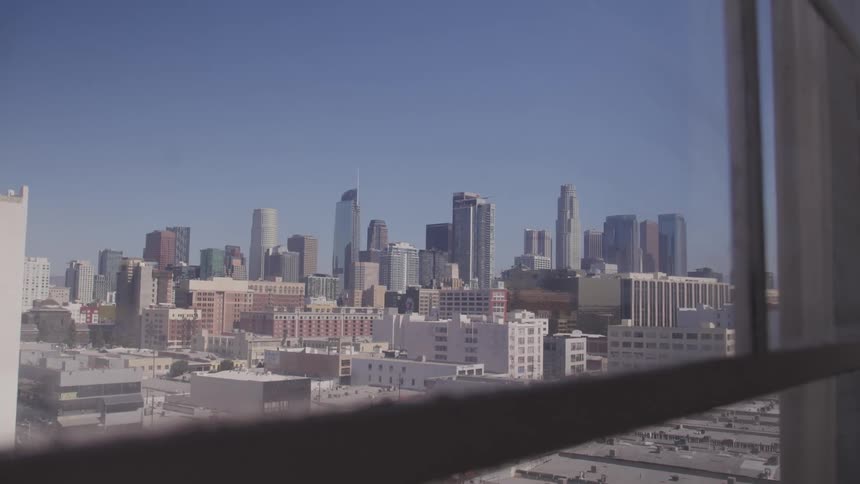 The city skyline and bright blue sky through the glass window panes of an apartment