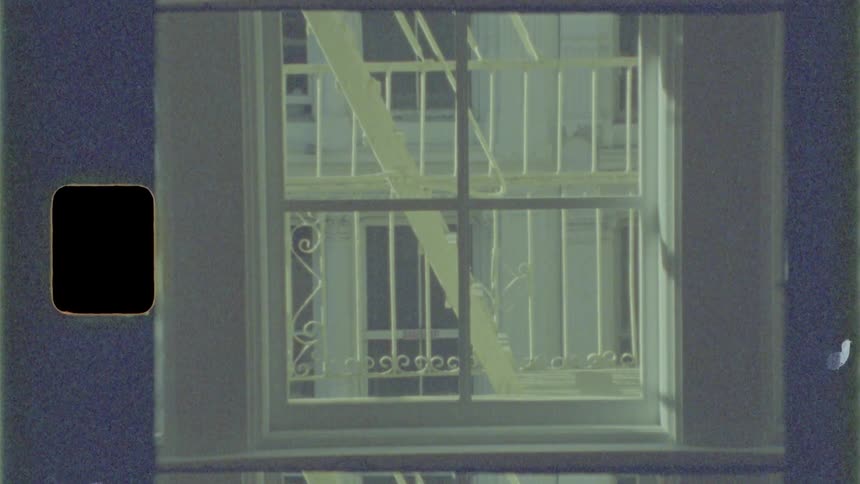 A building with multiple windows also has multiple metal staircases