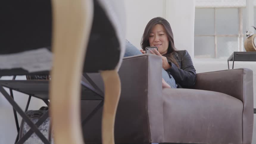 A woman smiles while on her phone