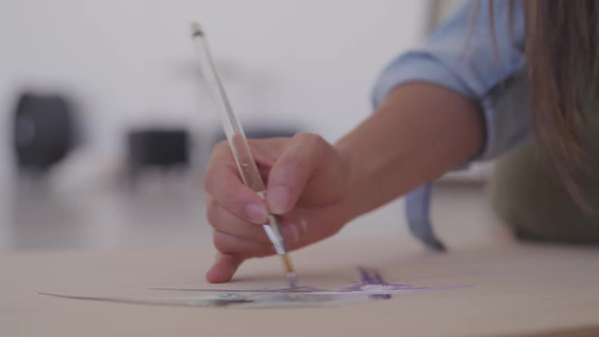 A woman sits and paints
