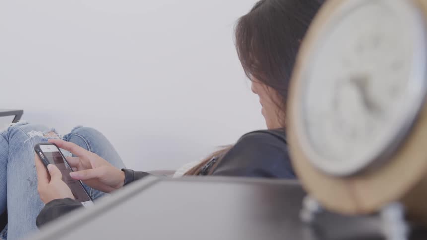Woman scrolls social media on smartphone