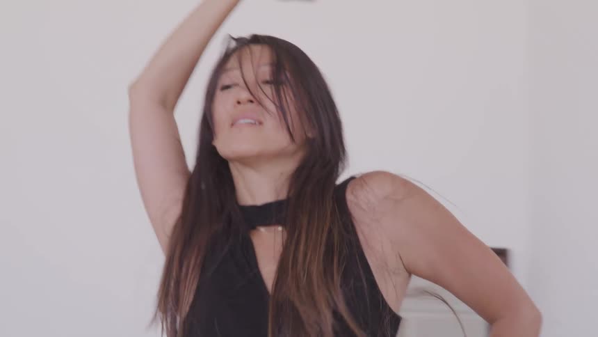 An asian woman dances inside
