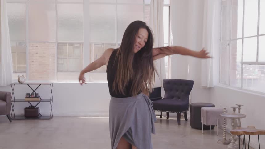 A woman is dancing in her apartment