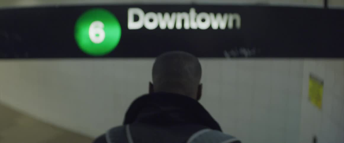 A man walks down steps to the subway station