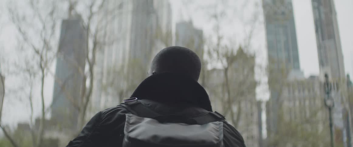Black man looks at the distant high rise buildings