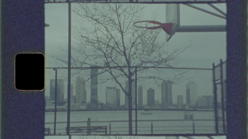 A basket ball court with the city skyline in the distance