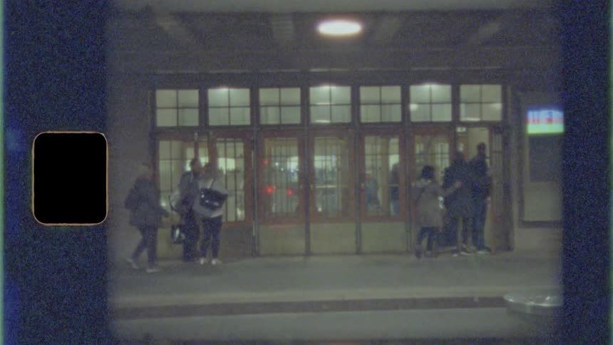 A large crowd of people walk into a theater