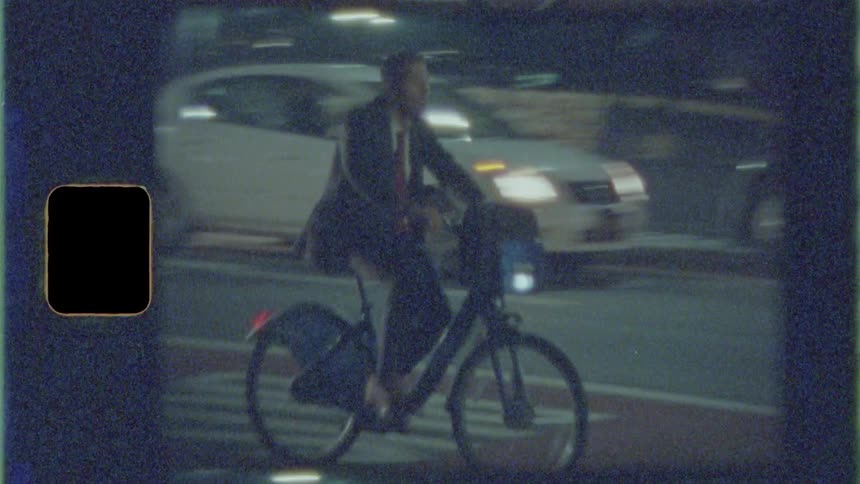 Businessman rides a bicycle on the road at night