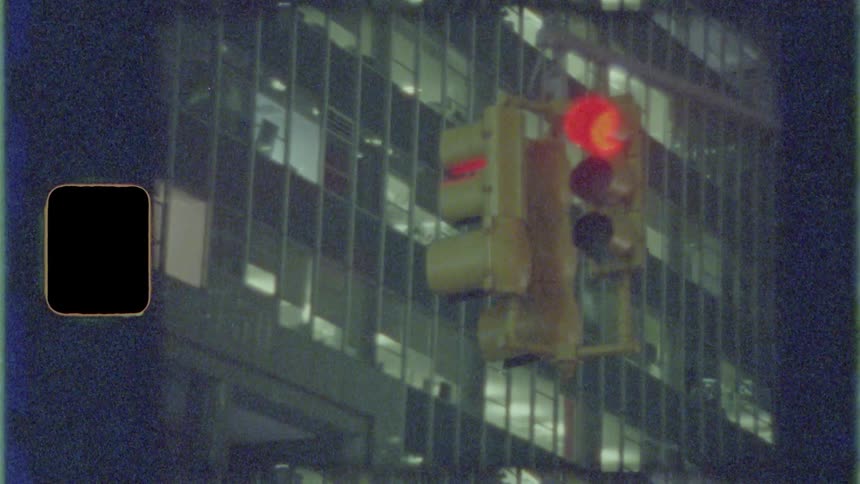 Traffic signal changing from red to green near an office building