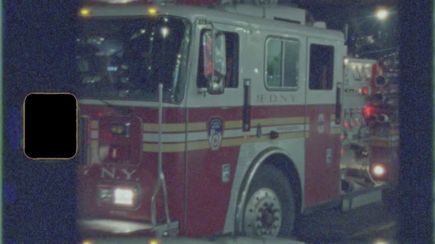 A fire truck is parked on the street at night