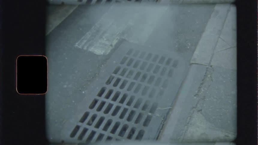 Steam rises from the storm drain in the street