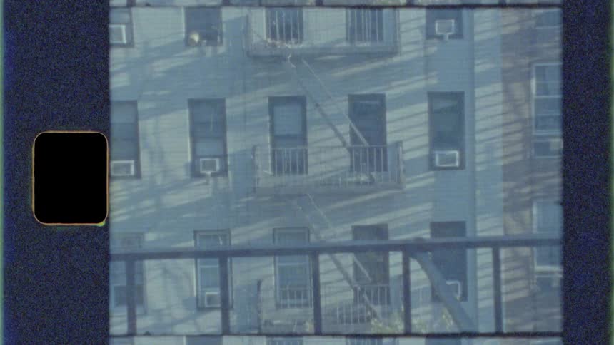 The fire escape runs up the side of the apartment buildings
