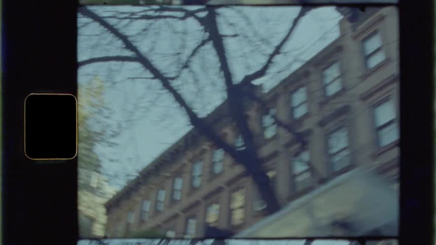 A large apartment building on a city street on a sunny day