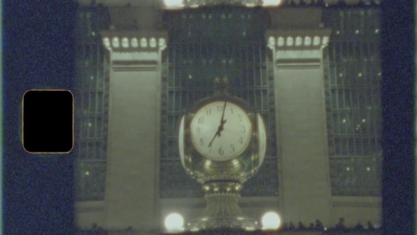 Large multifaced clock towers over information desk in crowded transit station