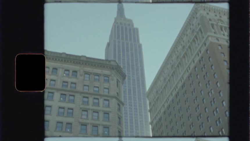 Skyscraper and large city buildings sit under a blue sky
