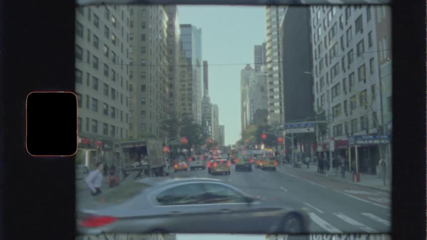 A vehicle makes a left turn in front of a person crossing a crosswalk in a big city