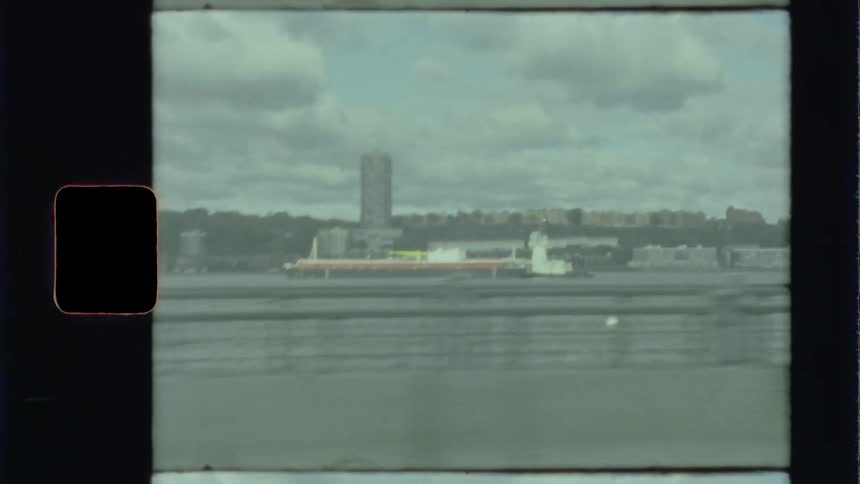 Traveling past a barge in a harbor near city buildings