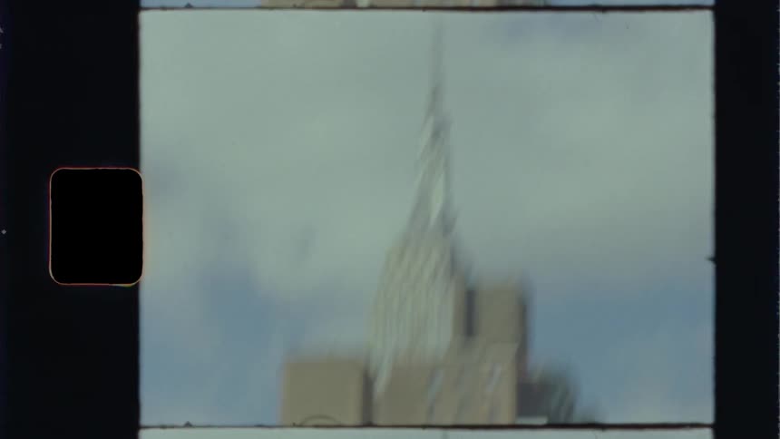 The empire state building against a blue sky from street level