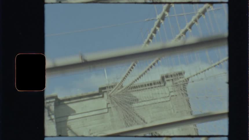 The view from a traveling cars rear window as it crosses a bridge on a bright sunny day