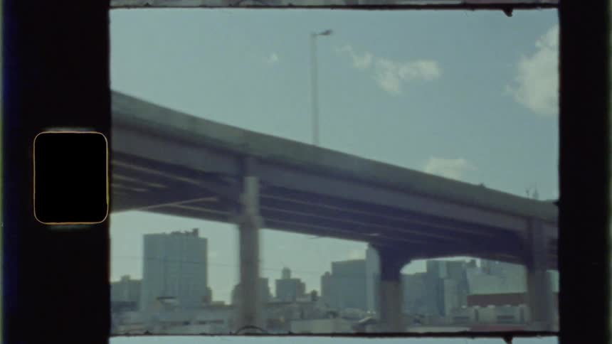A long bridge sits above neighborhoods in a city