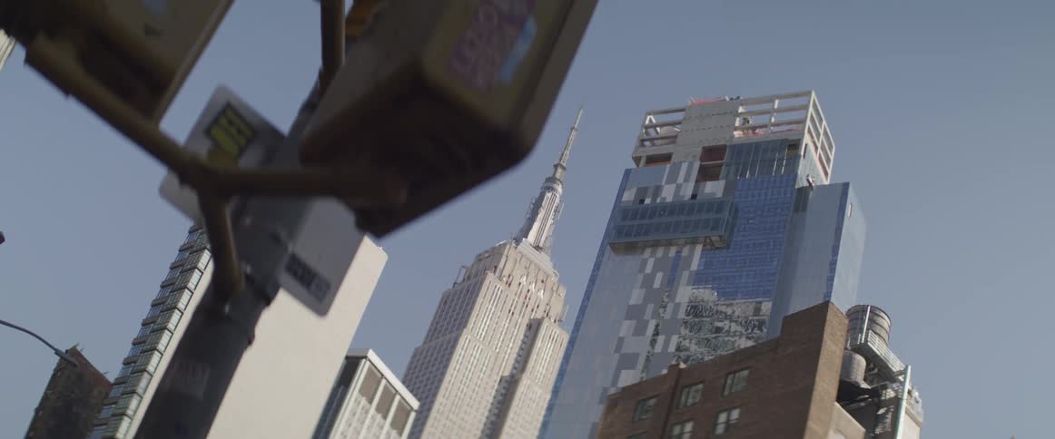 The empire state building and city on a bright blue sky day from street level