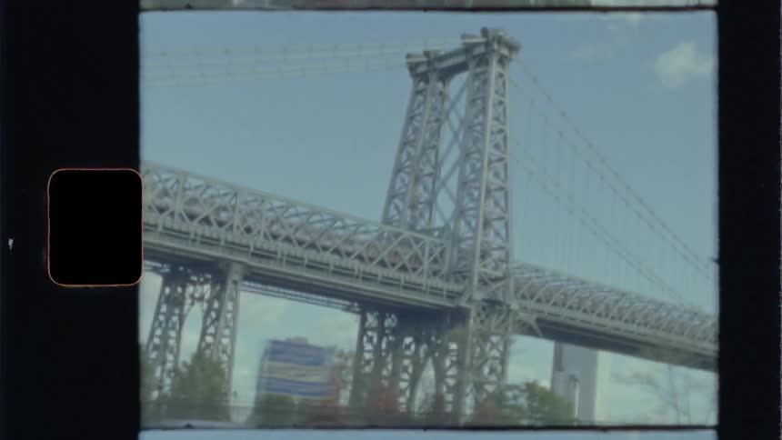 A suspension bridge is seen from a moving vehicle