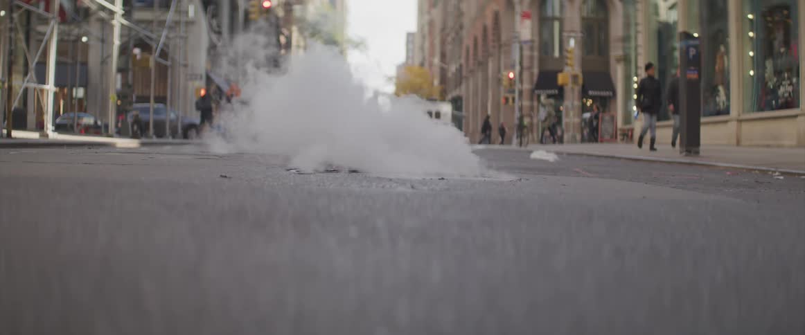 Steam coming out of manhole on the street of a city