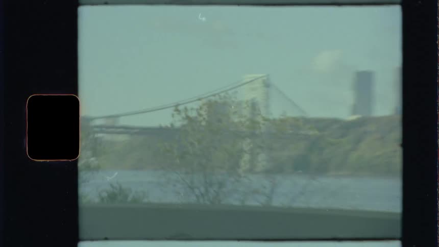 A large bridge over a river on the outskirts of a city