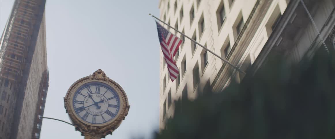 American flag flies near a building and a large clock