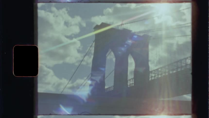 The sun shines bright over a suspension bridge in a city