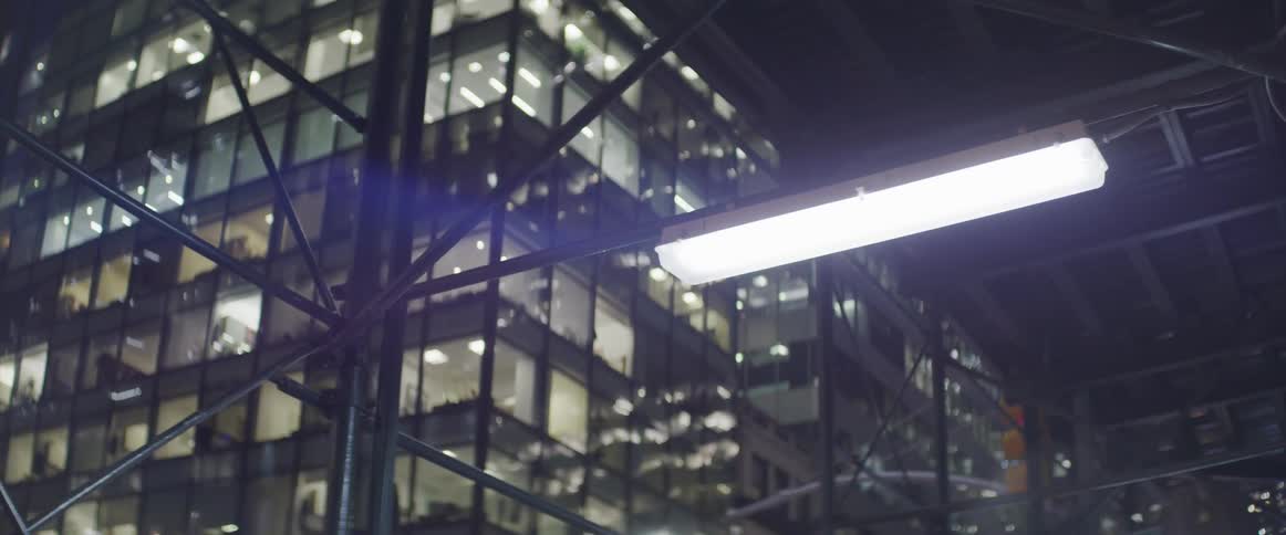 A light in a fixture illuminates the inside of a city building