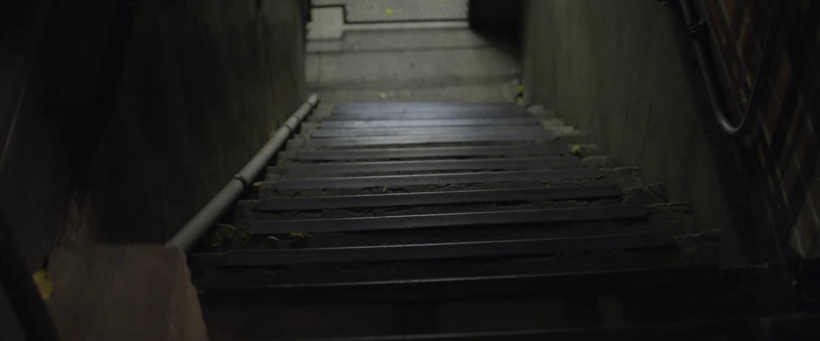 The stairwell is dark with light at the bottom