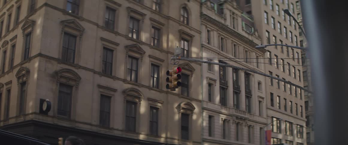 The traffic light is shining red near the building