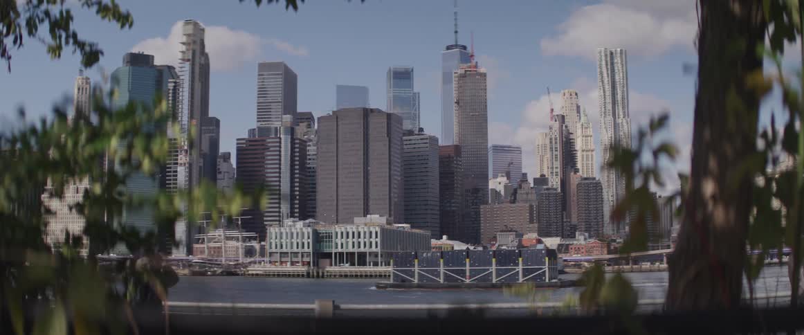 A cargo boat floats past the city skyline