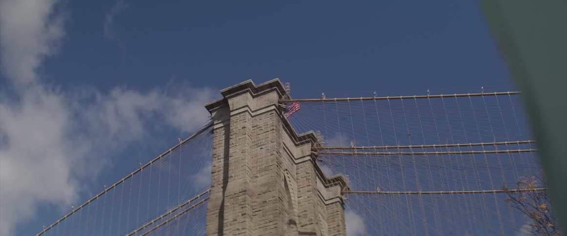 View of brooklyn bridge tower and the american flag flying
